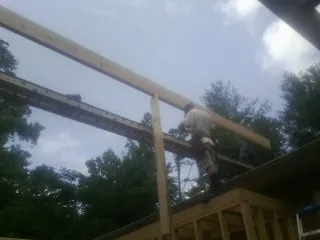 Carpenter setting a ridge beam over a new addition frame — Ice Dam Removal by Roofing Brothers in Roulette